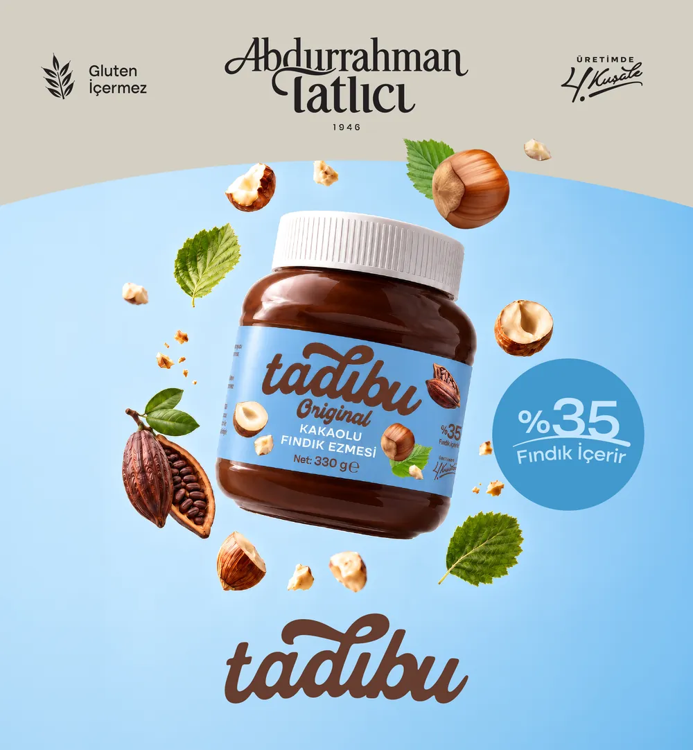 Mavi zeminde havada süzülen Tadıbu Original kakaolu fındık ezmesi ve fındıklar