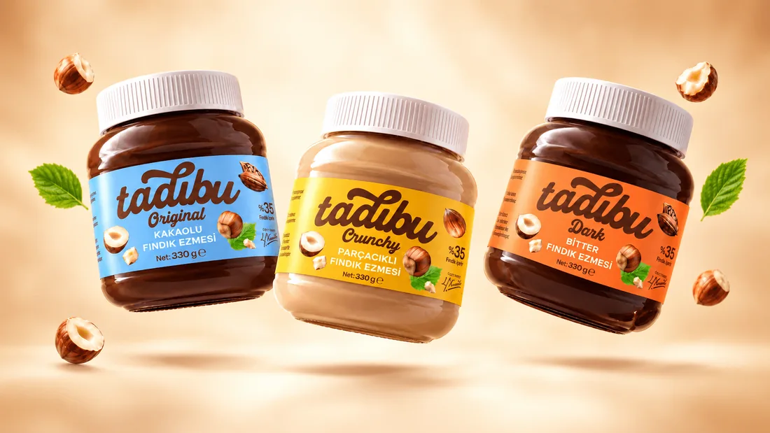 Havada süzülen Tadıbu Original, Crunchy ve Dark fındık ezmesi kavanozları ve fındıklar